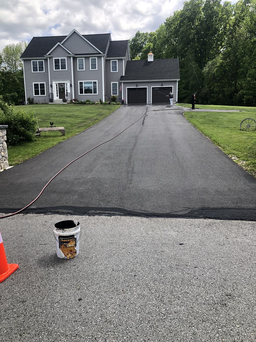 AAA Supercoat crew applying sealcoat on a residential driveway