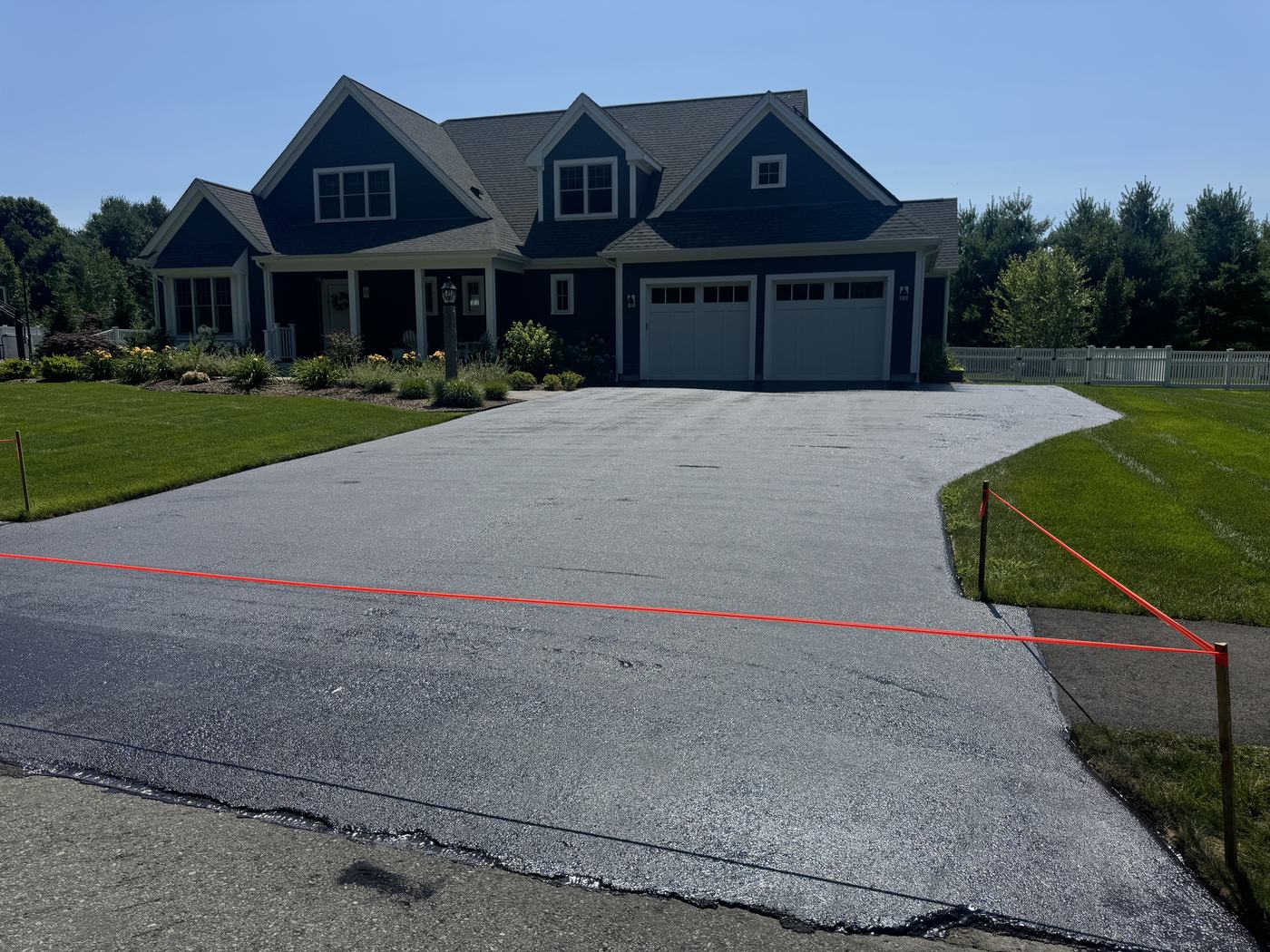 Sealed residential driveway leading to a two-car garage
